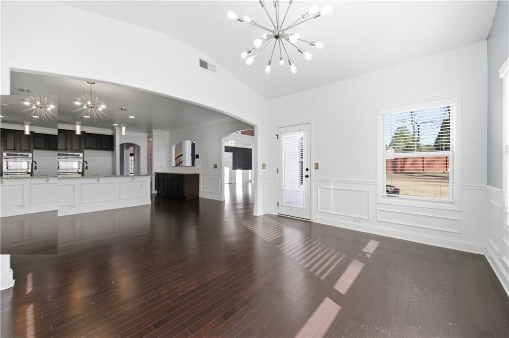 2813 Carrick Court Powder Springs, GA 30127 - Photo 12 of 47 a view of an empty room with wooden floor and a kitchen