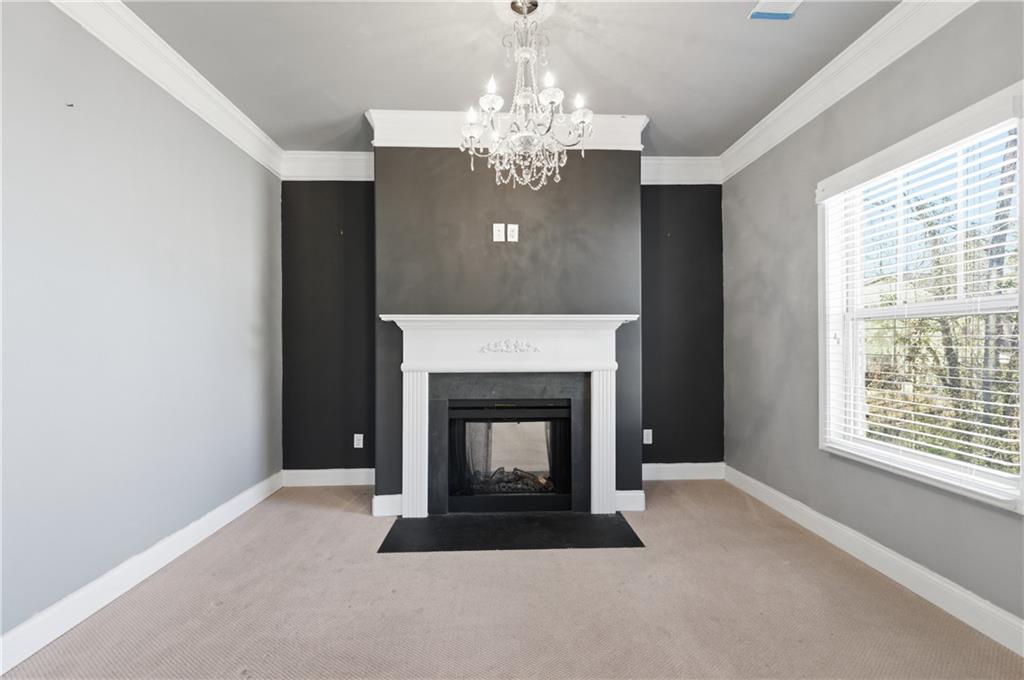 2813 Carrick Court Powder Springs, GA 30127 - Photo 26 of 47 a living room with a fireplace and chandelier