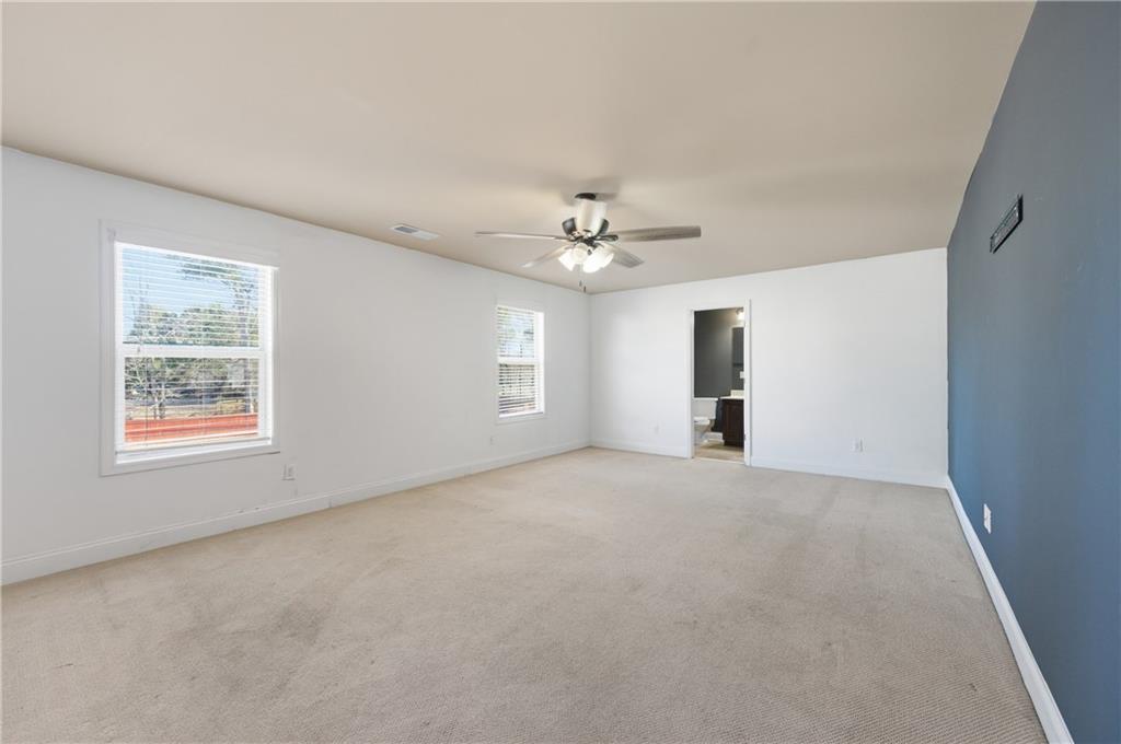 2813 Carrick Court Powder Springs, GA 30127 - Photo 31 of 47 an empty room with windows and chandelier fan