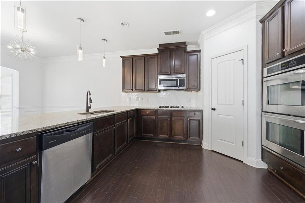 2813 Carrick Court Powder Springs, GA 30127 - Photo 10 of 47 a kitchen with kitchen island granite countertop a sink cabinets and stainless steel appliances