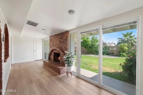 an empty room with wooden floor ceiling fan and windows