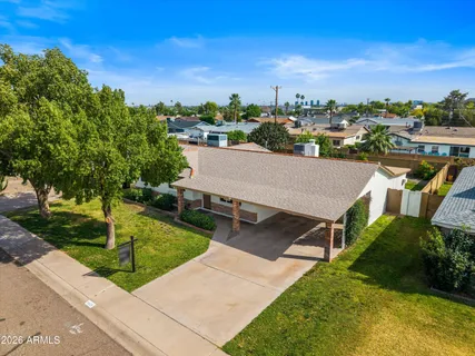 an aerial view of a house with swimming pool garden and tall buildings