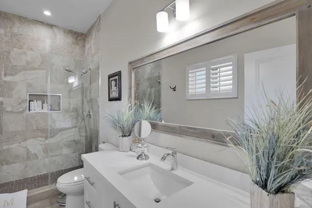 a bathroom with a sink a toilet and shower