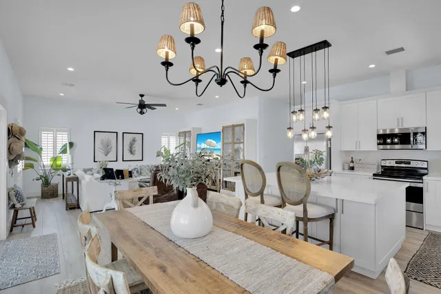 a living room with furniture a chandelier and kitchen view