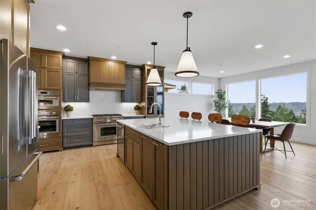 a kitchen with stainless steel appliances granite countertop a kitchen island a stove and a sink