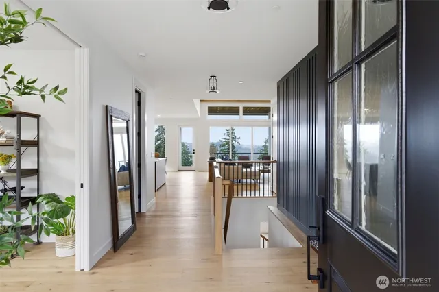 a view of a hallway with wooden floor and windows