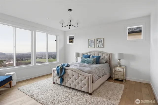 a bedroom with a bed chandelier and a window
