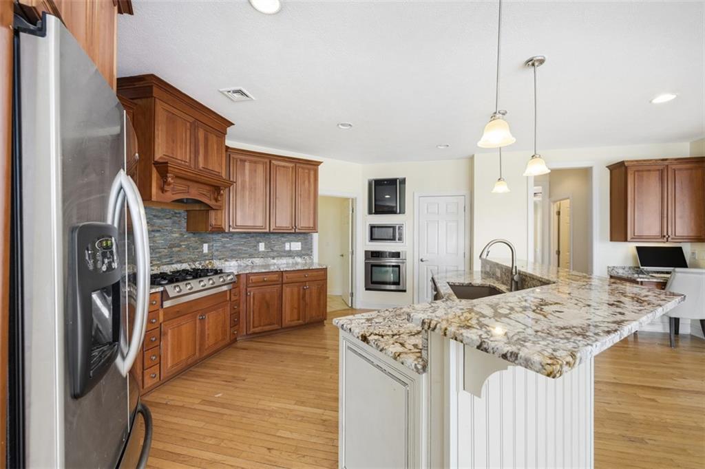 110 Timber Ridge Drive Harmony, PA 16037 - Photo 8 of 50 a kitchen with stainless steel appliances kitchen island granite countertop a stove refrigerator and cabinets