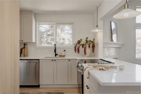 a view of cabinets a sink and a stove in a kitchen
