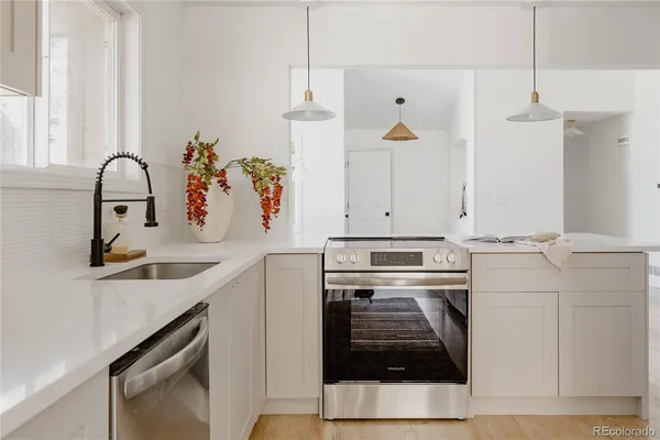 a kitchen with a sink a stove and cabinets