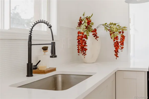 a kitchen with a white cabinets and chairs