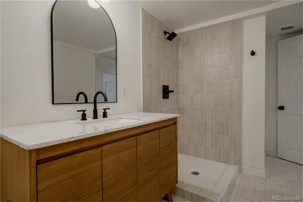 a bathroom with a sink a mirror and shower