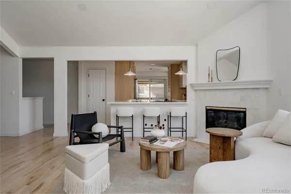 a living room with furniture a fireplace and a potted plant