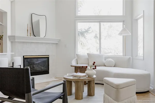 a living room with furniture a fireplace and a large window