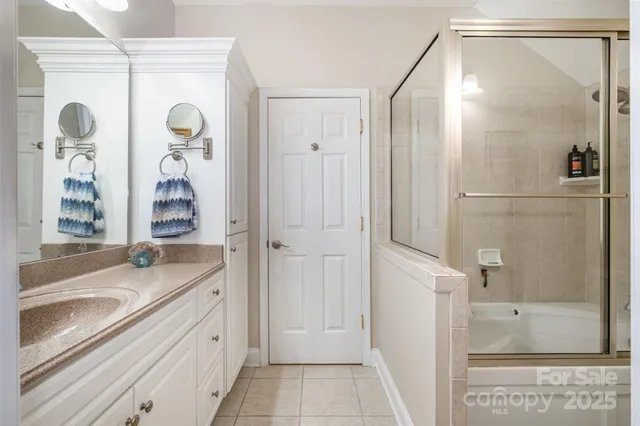a bathroom with a granite countertop sink mirror and a shower