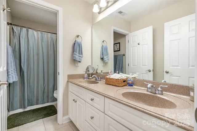 a bathroom with double vanity sinks and a mirror