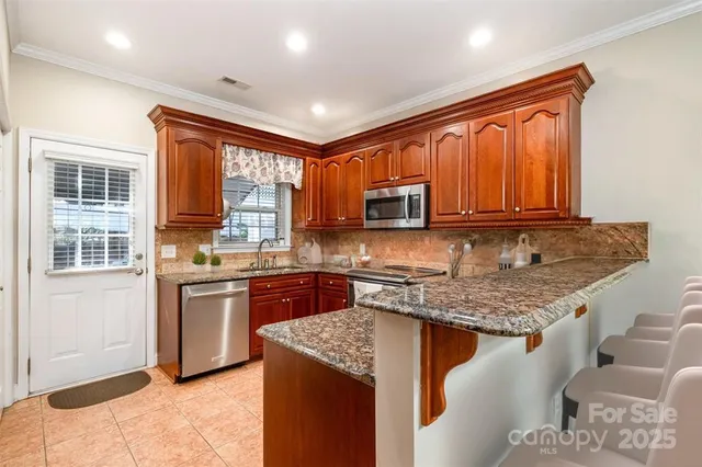 a kitchen with stainless steel appliances granite countertop stove microwave and sink
