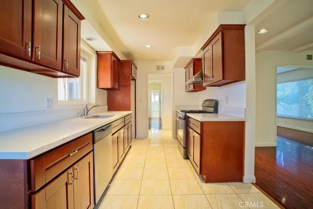 a kitchen with stainless steel appliances granite countertop a stove a sink and a refrigerator