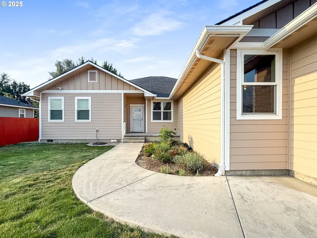 a view of a house with a small yard and potted plants
