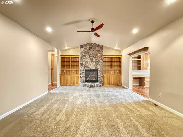 a view of a livingroom with a chandelier fan and a fireplace