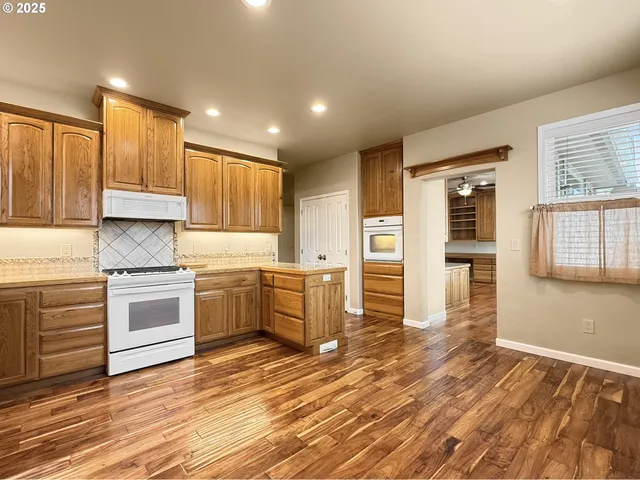 a kitchen with granite countertop a stove top oven and cabinets