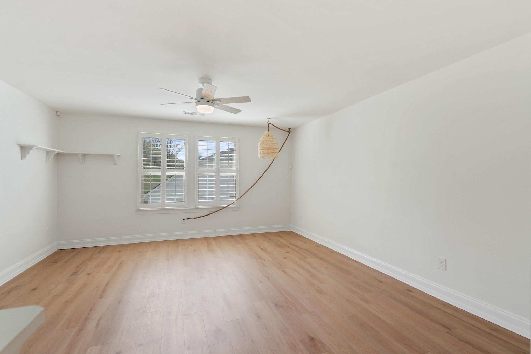2056 Notchleaf Road Antioch, TN 37013 - Photo 28 of 42 an empty room with wooden floor chandelier fan and windows