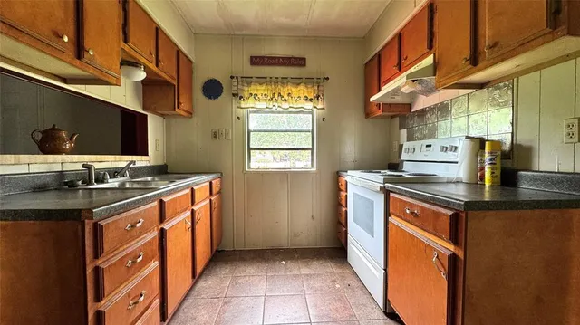 a kitchen with stainless steel appliances granite countertop a sink and a stove