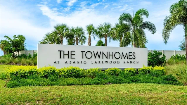 a sign of golf club on a wall under a tree