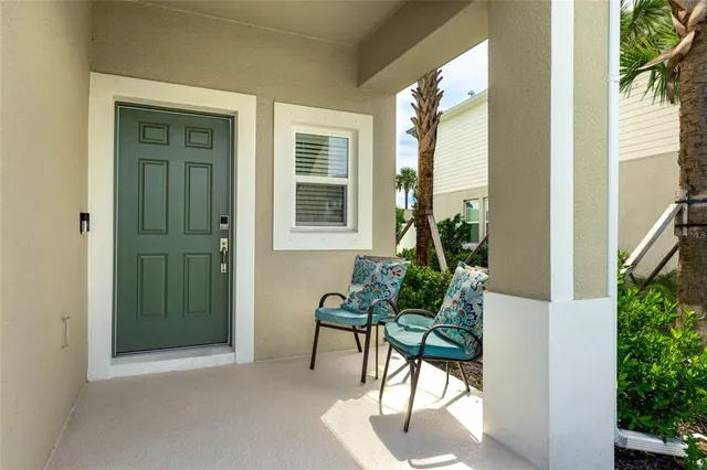 a view of a porch with chairs and potted plants