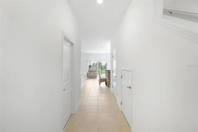 a hallway with white cabinets and wooden floor