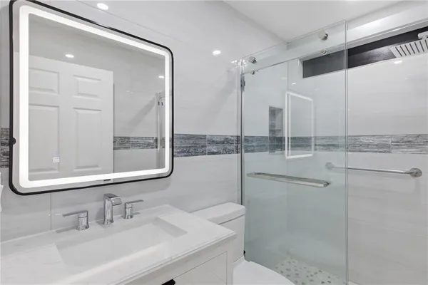 a bathroom with a shower sink and mirror
