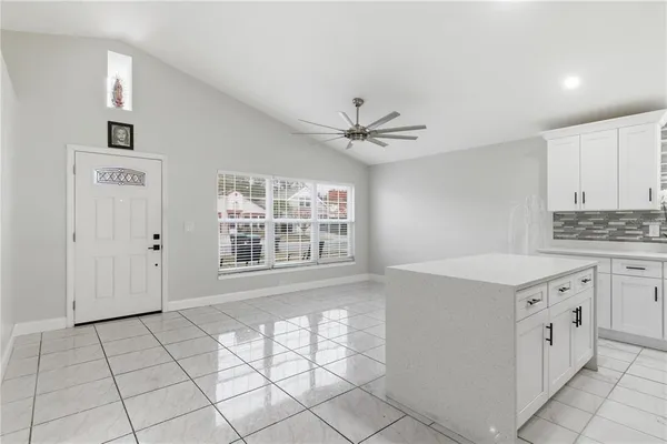 a view of kitchen with granite countertop cabinets and window