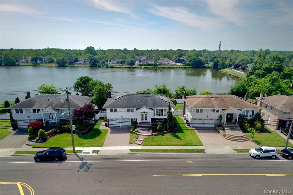 a aerial view of a house with outdoor space and lake view in back