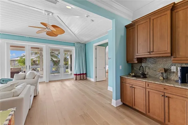 a open kitchen with stainless steel appliances granite countertop a dishwasher a stove a microwave oven a dining table and chairs with wooden floor