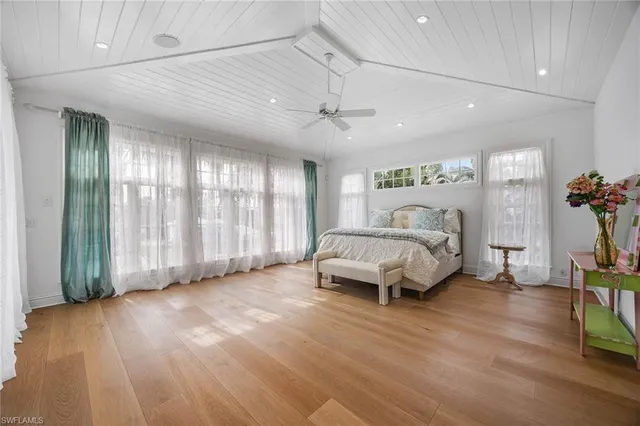 a spacious bedroom with a bed and a chandelier