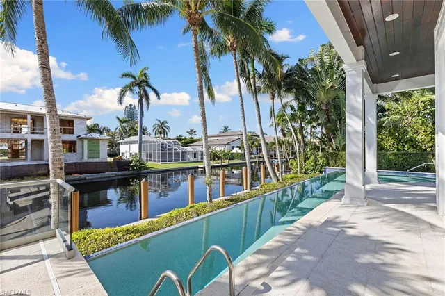 a view of a swimming pool with a patio and a yard