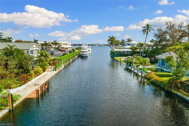a view of an ocean with boats and trees in the background