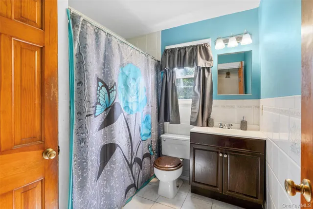 a bathroom with a toilet a sink and a mirror