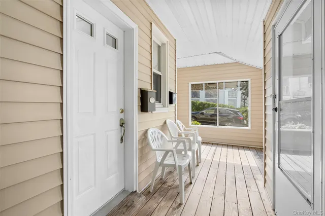 a view of front door deck and a barbeque with wooden floor