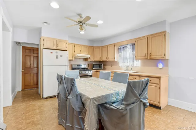 a kitchen with stainless steel appliances granite countertop a refrigerator a stove a sink dishwasher and a dining table with wooden floor