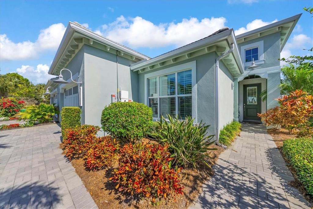 5756 Elbow Avenue Naples, FL 34113 - Photo 2 of 45 View of side of home featuring stucco siding and an attached garage