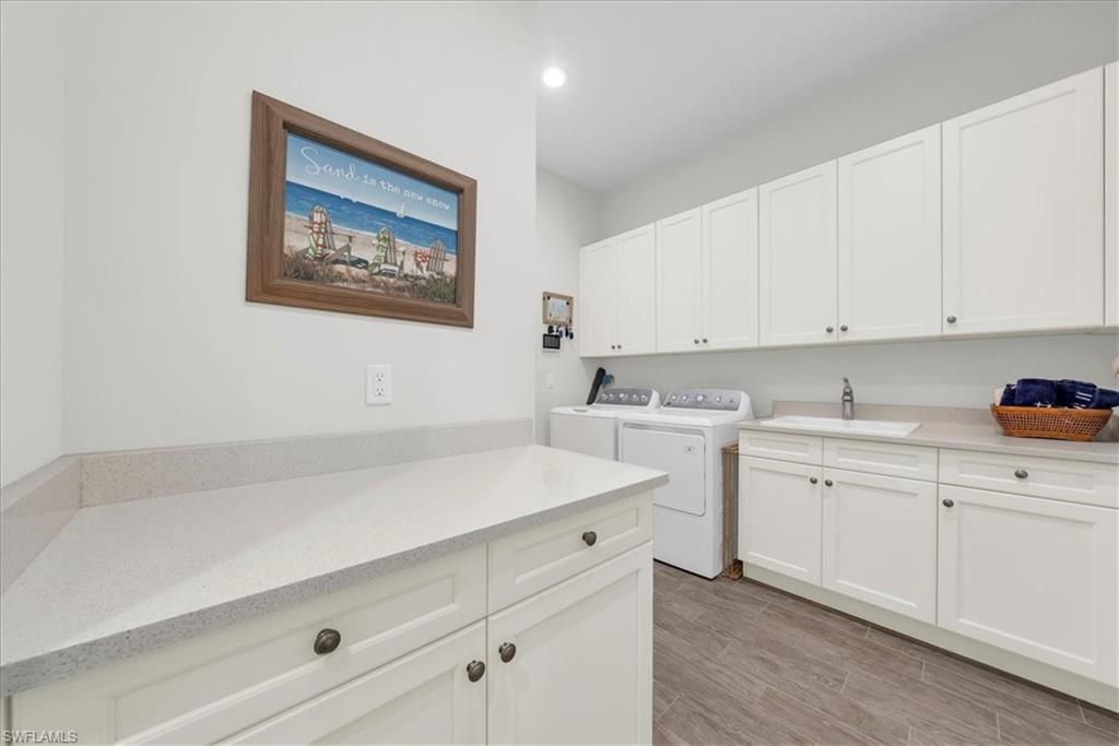 5756 Elbow Avenue Naples, FL 34113 - Photo 25 of 45 Laundry room featuring cabinet space, washing machine and dryer, wood finish floors, and recessed lighting