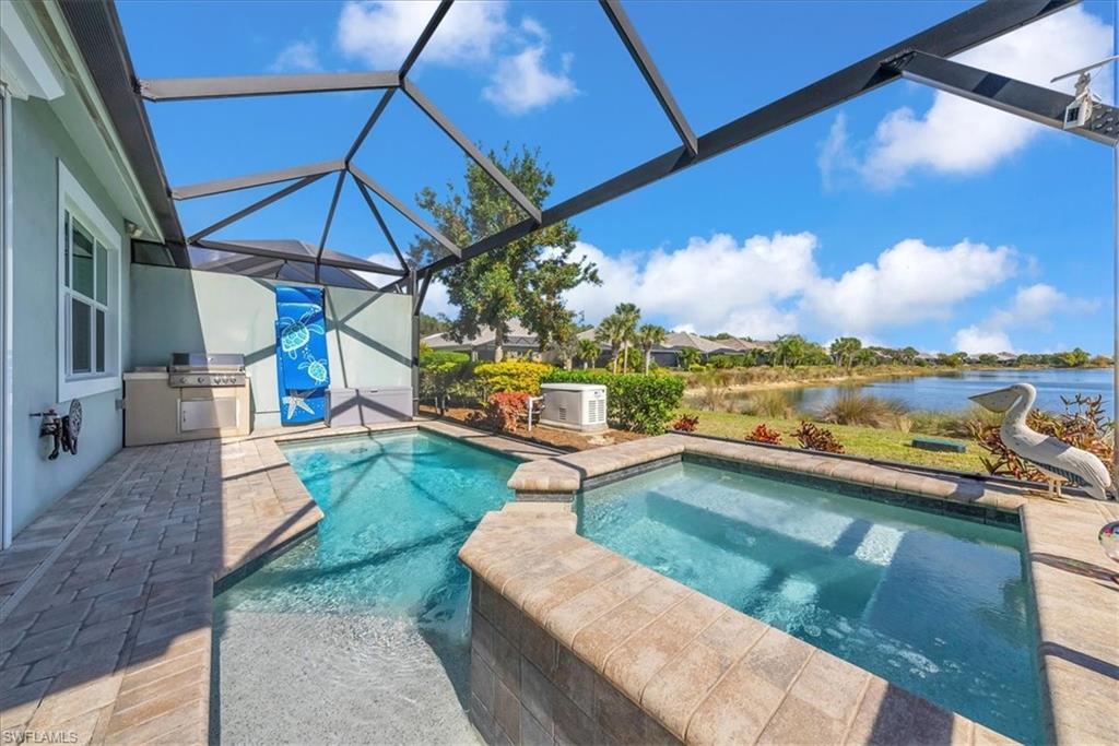 5756 Elbow Avenue Naples, FL 34113 - Photo 6 of 45 View of pool featuring a patio area, a sunroom, glass enclosure, an outdoor kitchen, and a pool with connected hot tub