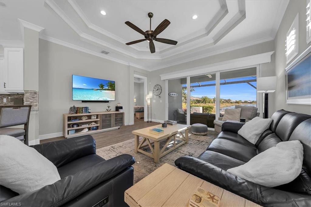 5756 Elbow Avenue Naples, FL 34113 - Photo 7 of 45 Living room with ornamental molding, wood finished floors, a ceiling fan, a raised ceiling, and recessed lighting