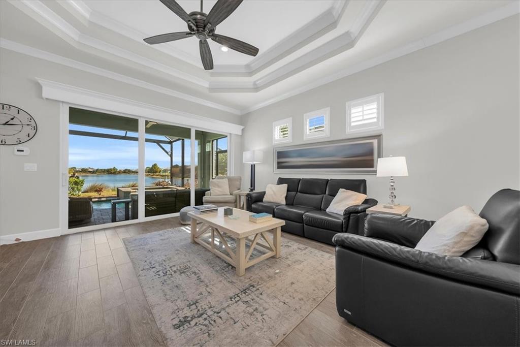 5756 Elbow Avenue Naples, FL 34113 - Photo 8 of 45 Living area featuring a water view, ornamental molding, wood finished floors, a raised ceiling, and a sunroom