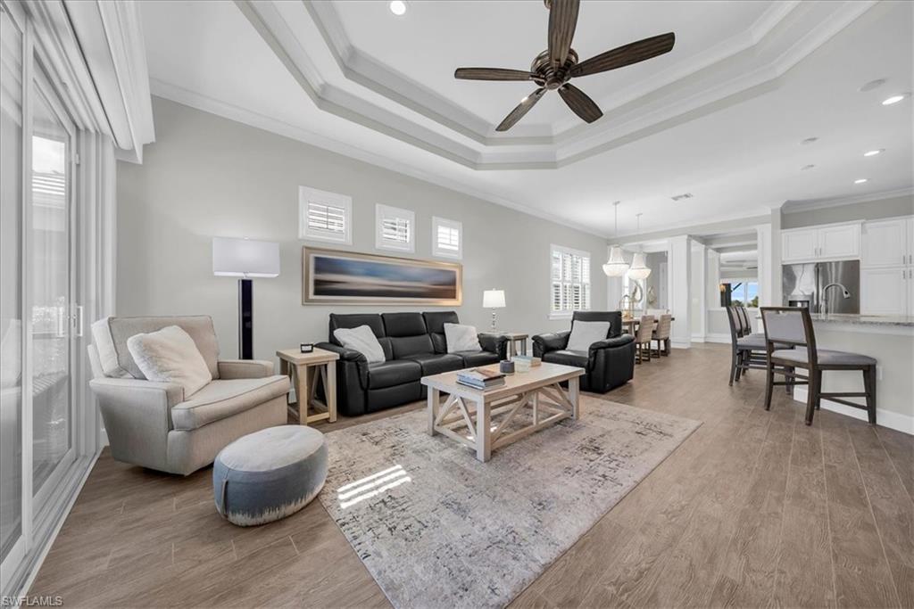 5756 Elbow Avenue Naples, FL 34113 - Photo 10 of 45 Living room with light wood-style floors, ornamental molding, ceiling fan, a tray ceiling, and recessed lighting