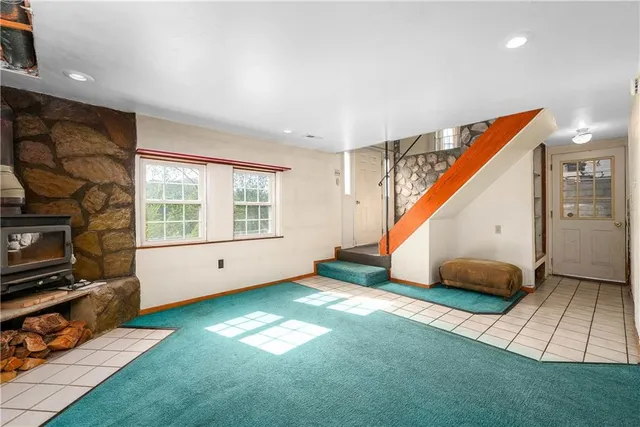 a view of an empty room with a fireplace and a window