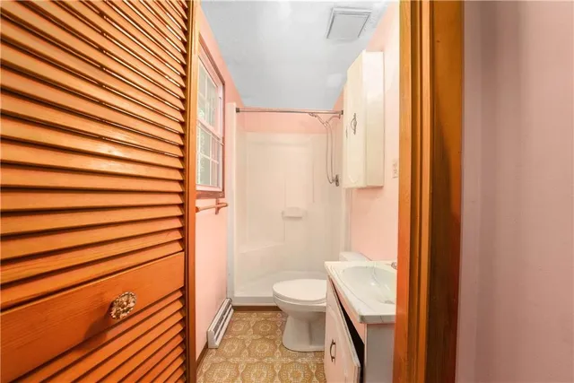 a bathroom with a toilet and a shower