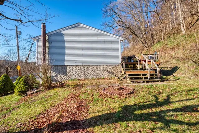 a front view of house with yard and trees in the background