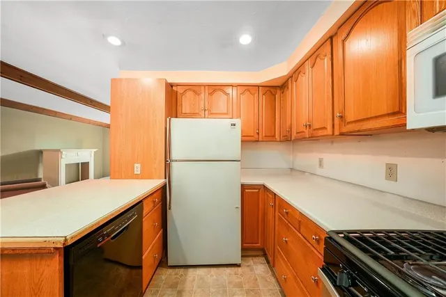 a kitchen with a refrigerator a stove a sink and cabinets